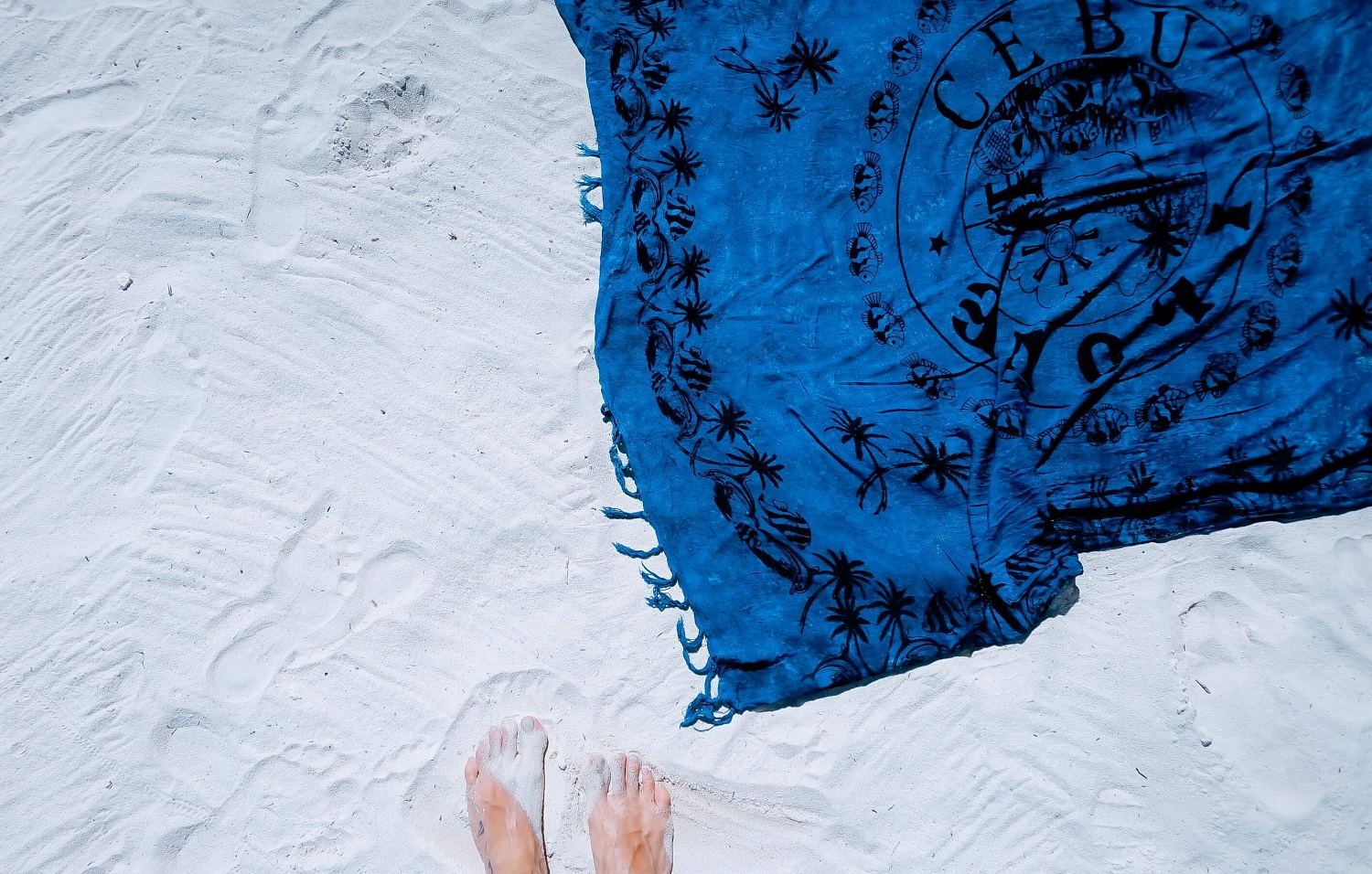 blaues Strandtuch auf weißem Sand